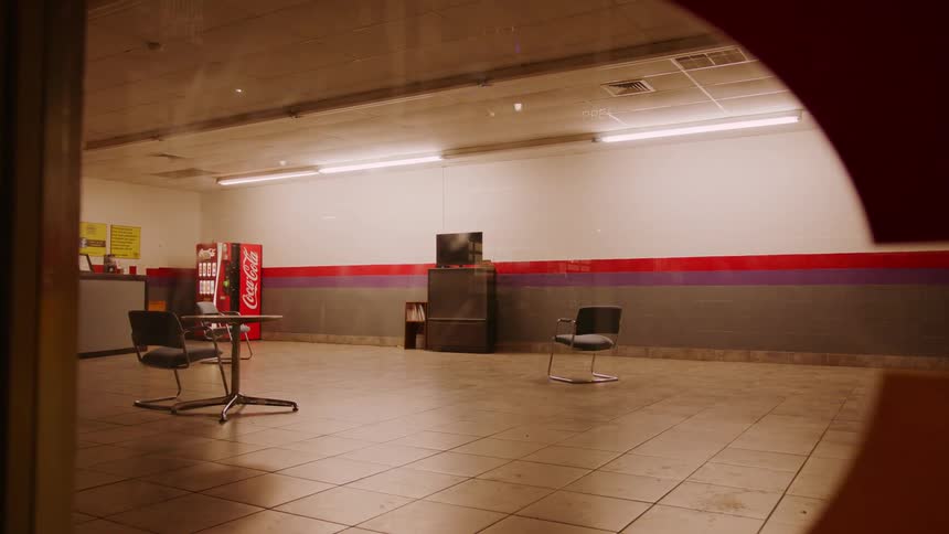 An empty break room with a vending machine in the corner