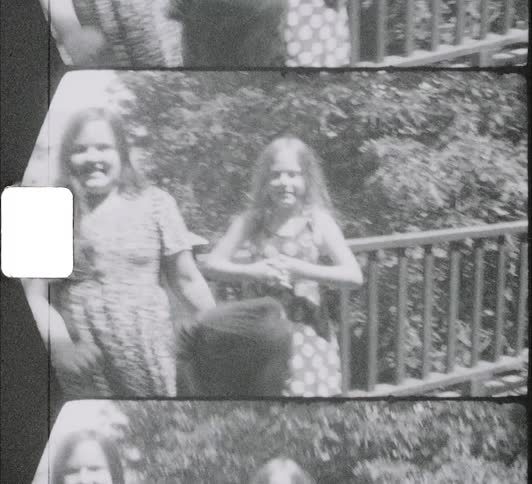 A group of young sisters pose playfully on a balcony as they are filmed