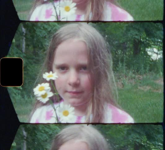 A young girl hold flowers in her hands while staring into the camera 8mm