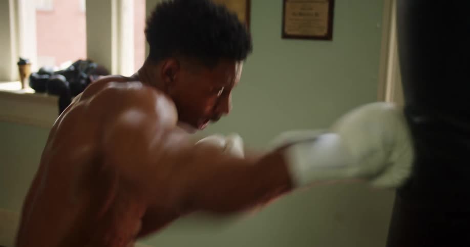 A boxer delivers powerful punches to a punching bag