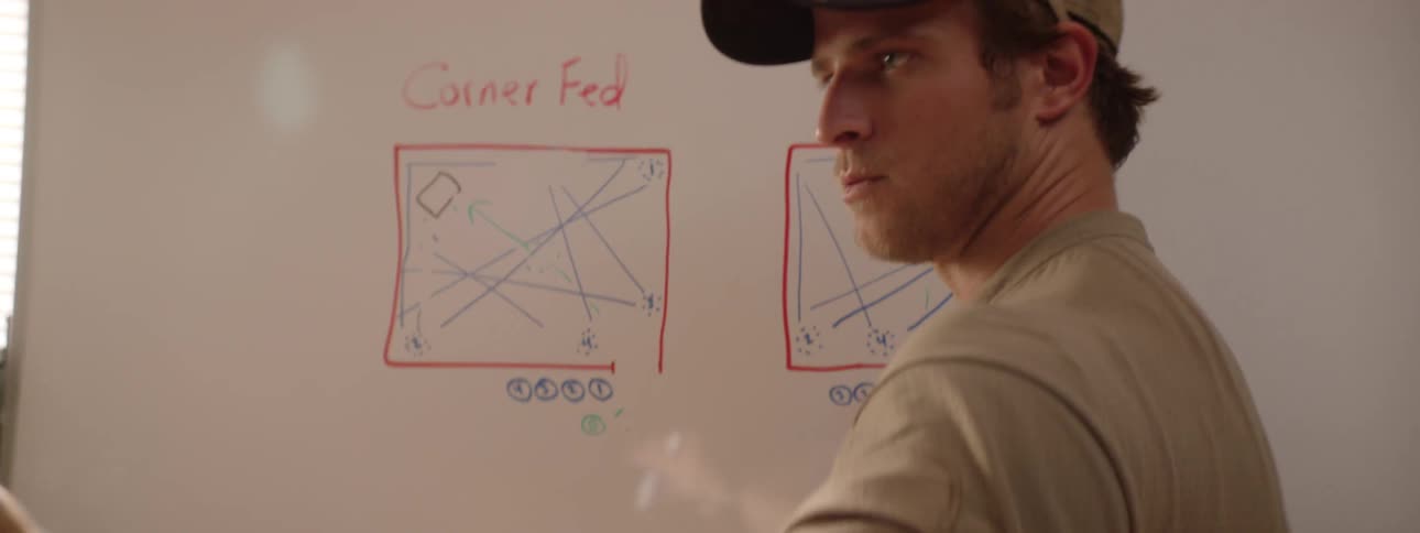A man is writing on a whiteboard
