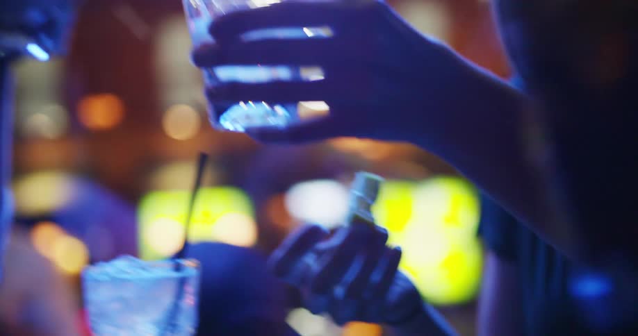 Three women in a bar all take a drink together