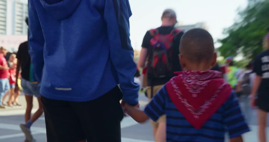 Boy walks in rally march with parent