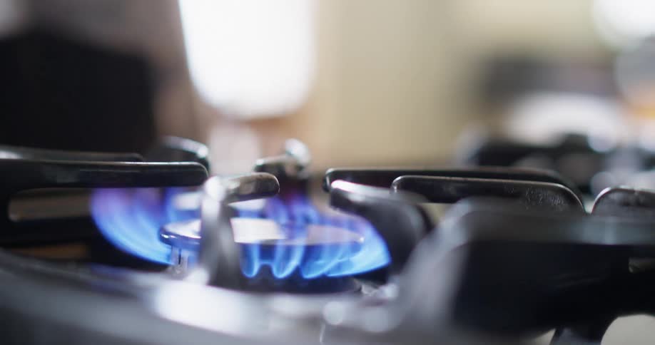 A flame burns on a gas stove