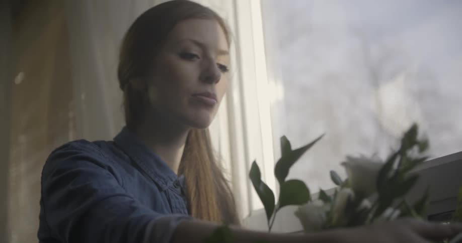 A woman is arranging some flowers