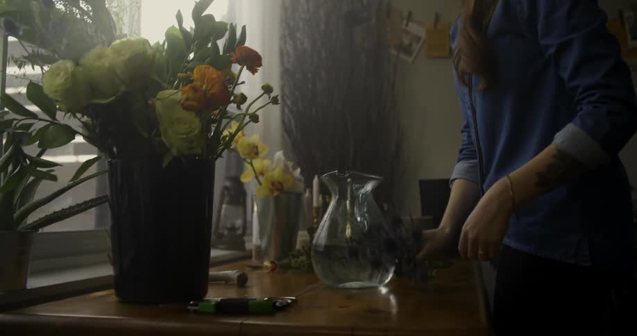 A woman takes flowers out of a vase