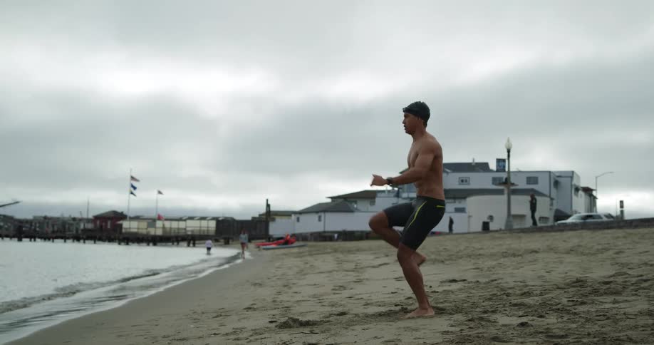 A man is jogging in place on the beach