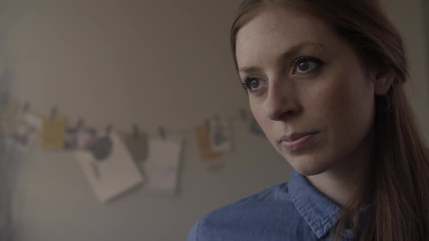 A woman slowly looks up in a room staring forward