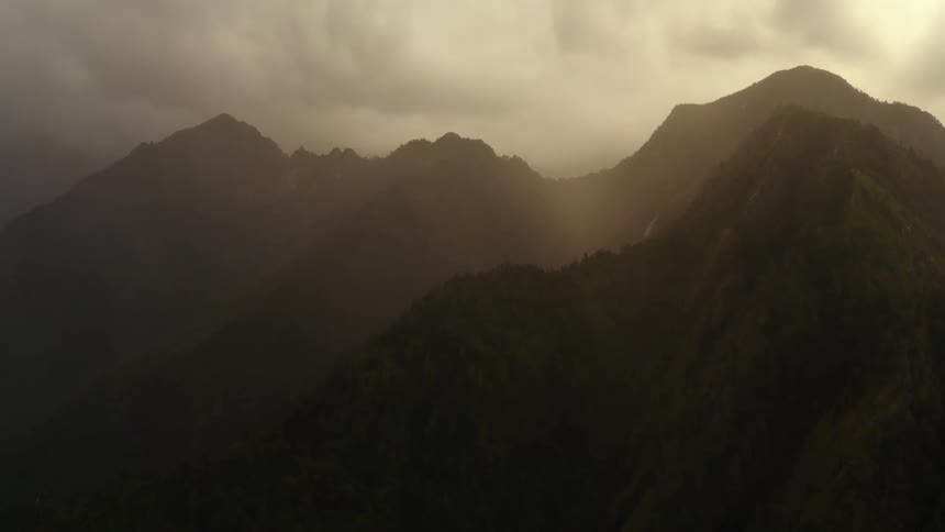 An aerial view of mountains at dusk is displayed