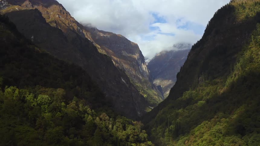 A river in a valley with a mountain range the sky and clouds in the background