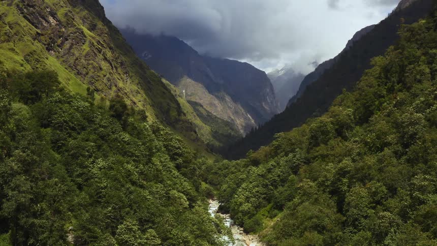 A river in a valley with a mountain range the sky and clouds in the background