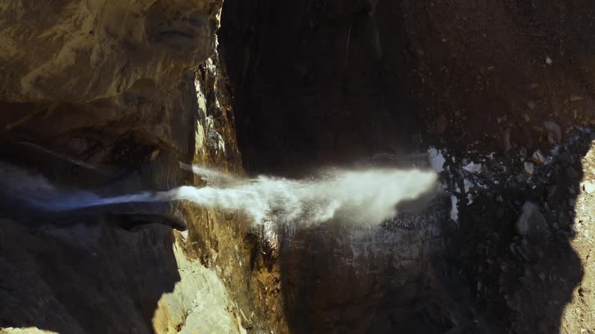 The water is pouring off the cliff