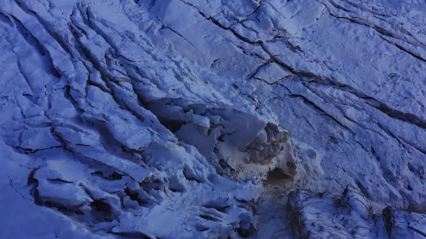 A snow and ice covered mountain range with light and shadow