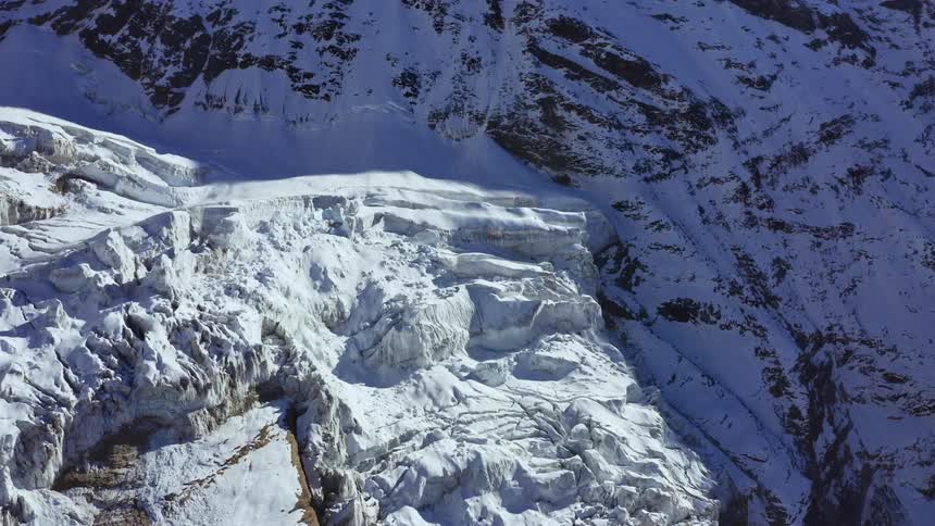 An aerial view of snow covered mountains is displayed