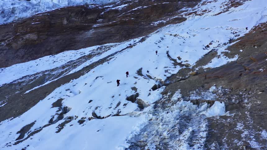 Four hikers hiking in snow on a mountain