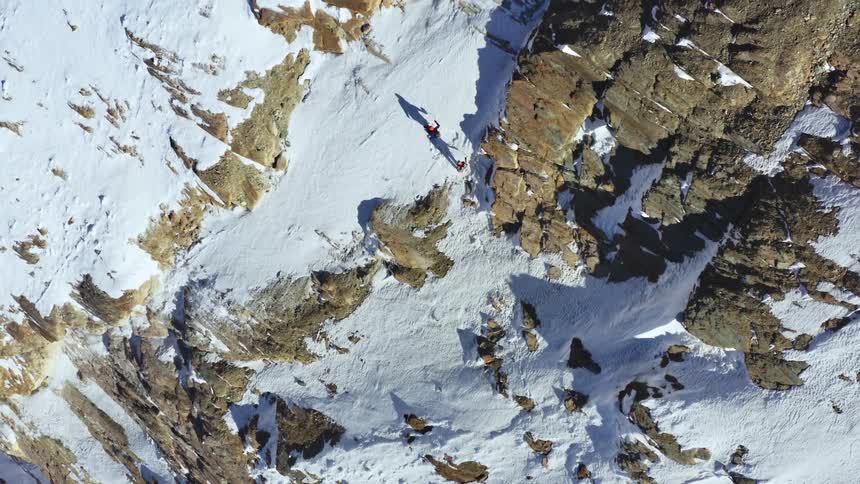 Aerial view of two people climbing a mountain