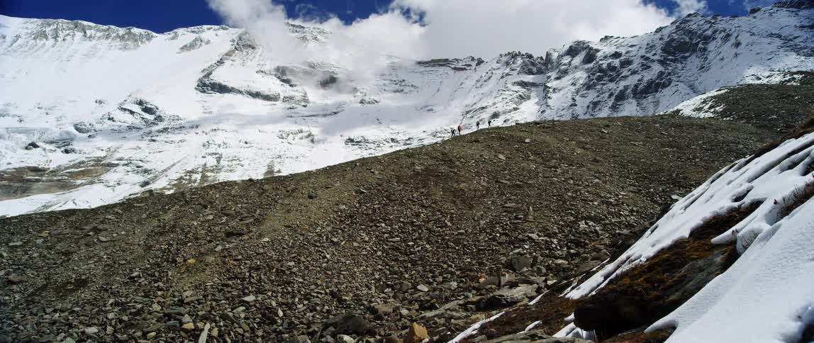 Four people climbing up a mountain