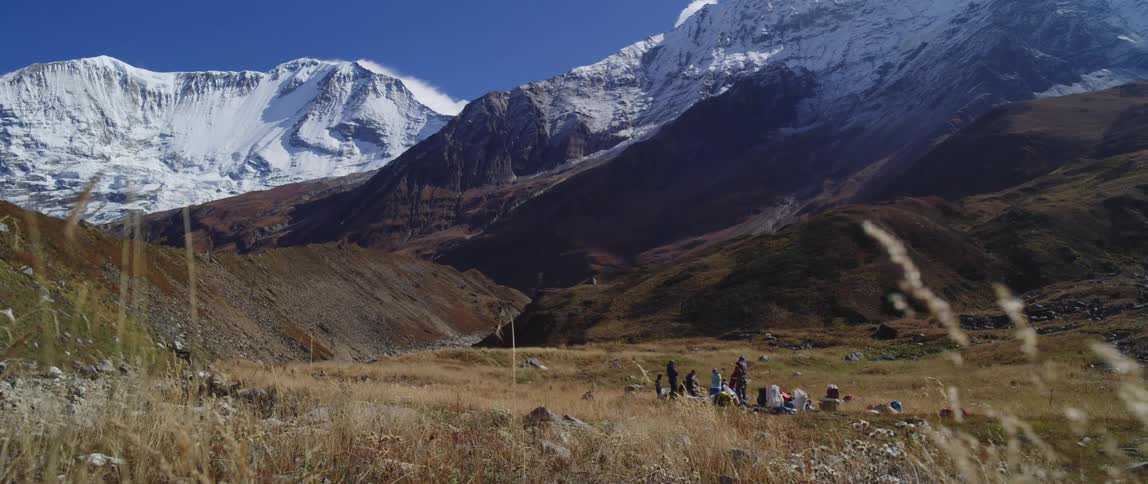 A group of campers rest mid day at the base of a mountain