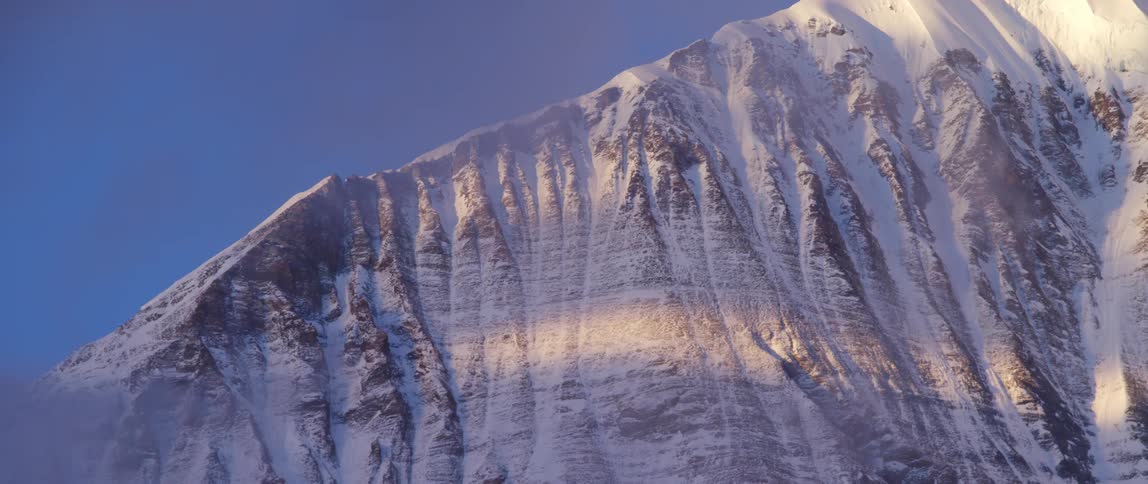 Aerial view of a snow covered mountain at dusk