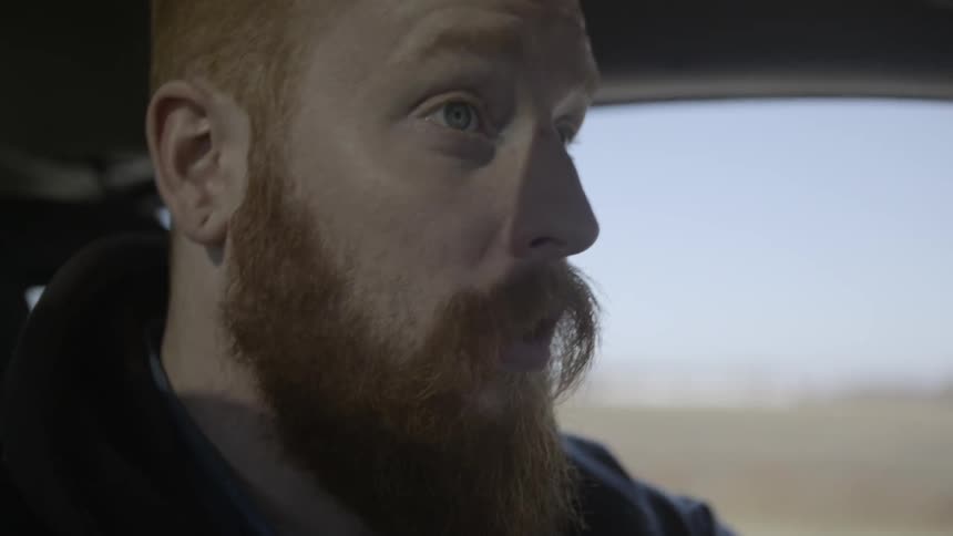 A man looks over his shoulder as he drives