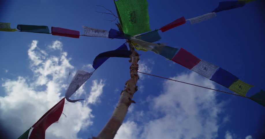 Green red white and blue flags waving in the wind with the sky and clouds above