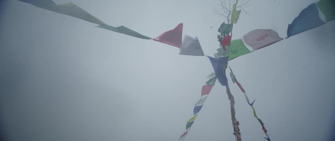 Multicolored prayer flags above smoke