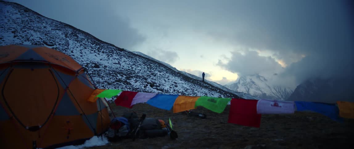 A campsite with flags on a snowy mountain