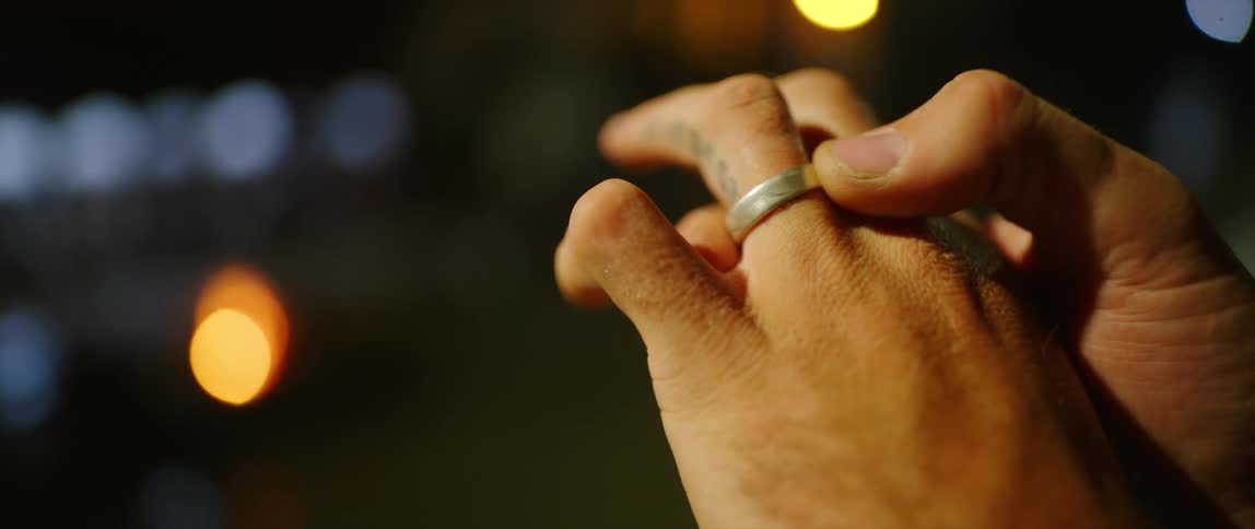 Person twisting silver ring around ring finger