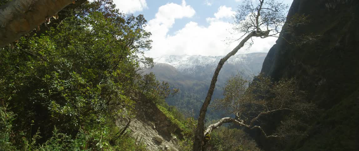 Extensive snow covered mountain range can be seen through mountain pass