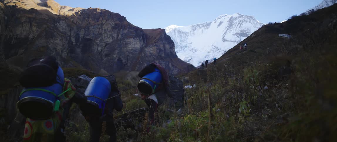 People are hiking up the mountain with containers