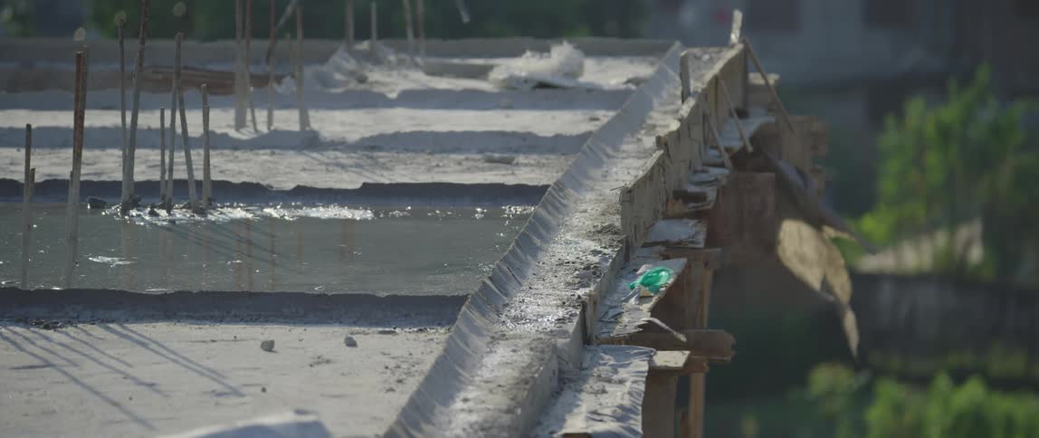 A pair of birds land on the edge of a rooftop before flying away
