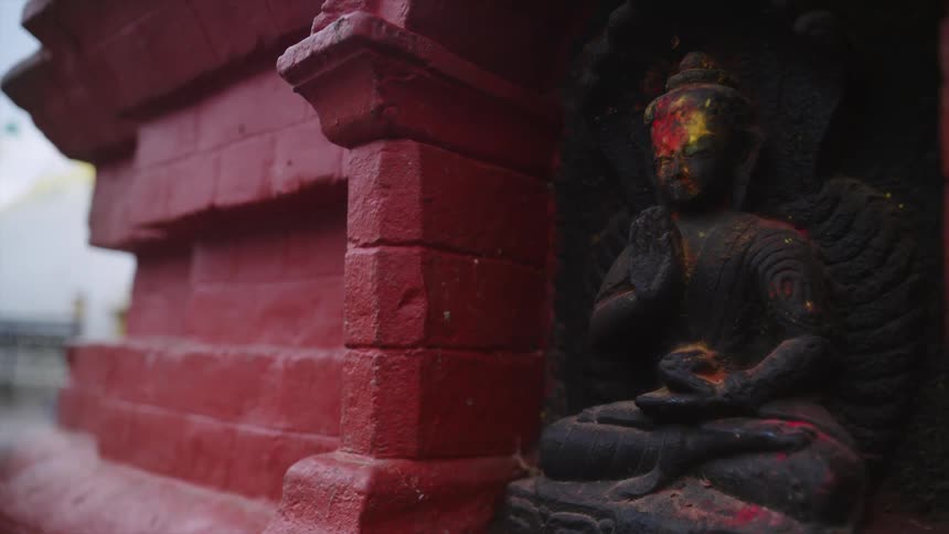 An old religious sculpture attached to an outdoor brick wall