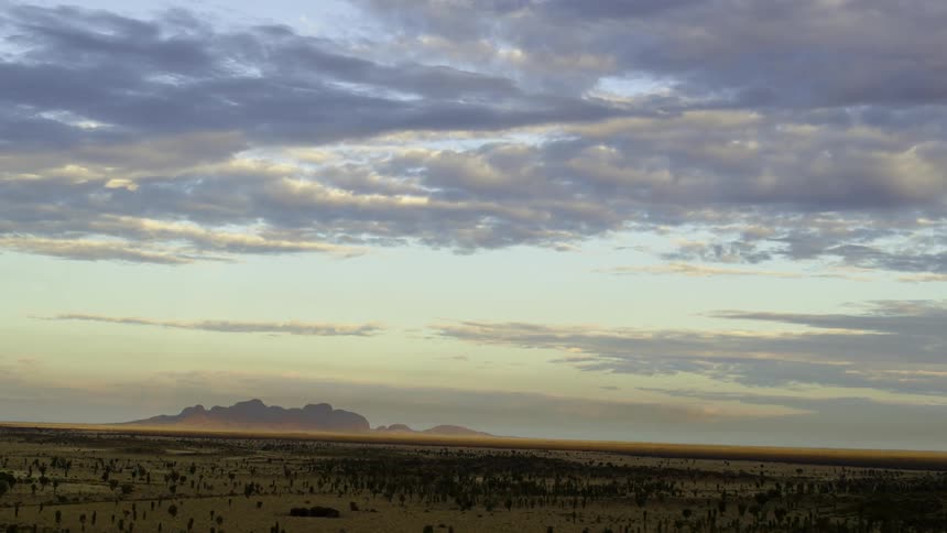 Vast flat savanna in front of distant mountains
