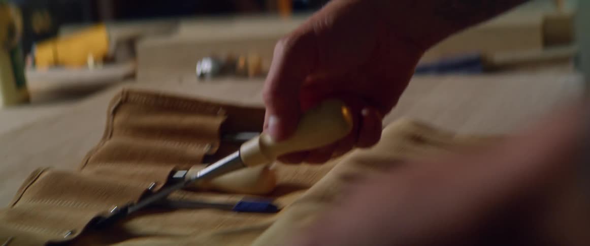 A man in his garage picks up a screwdriver