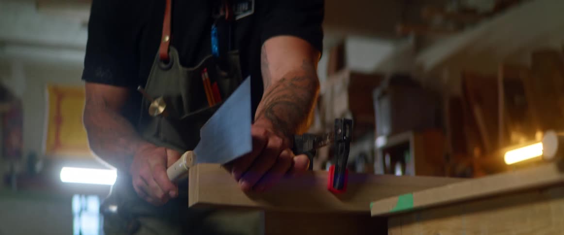 A man sawing wood in a workshop