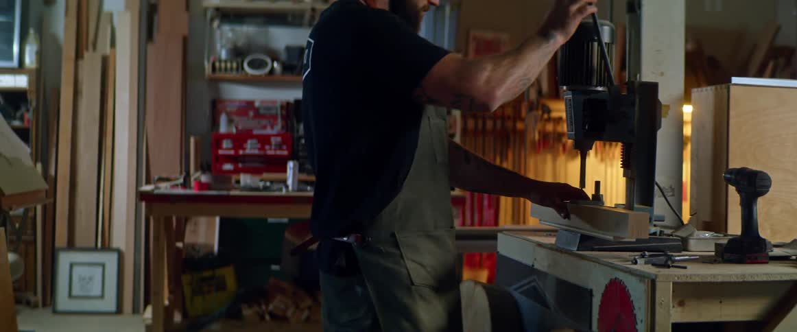 A man uses a tool in his garage