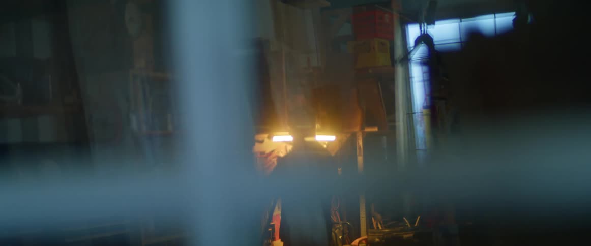 A man going and getting clamps off a wall in a workshop