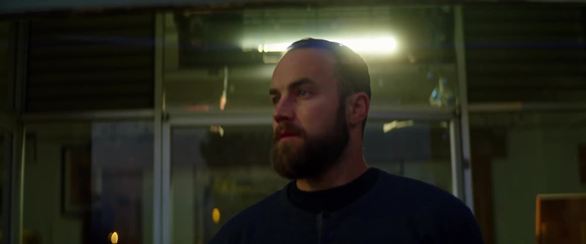 A man is walking into a building at night