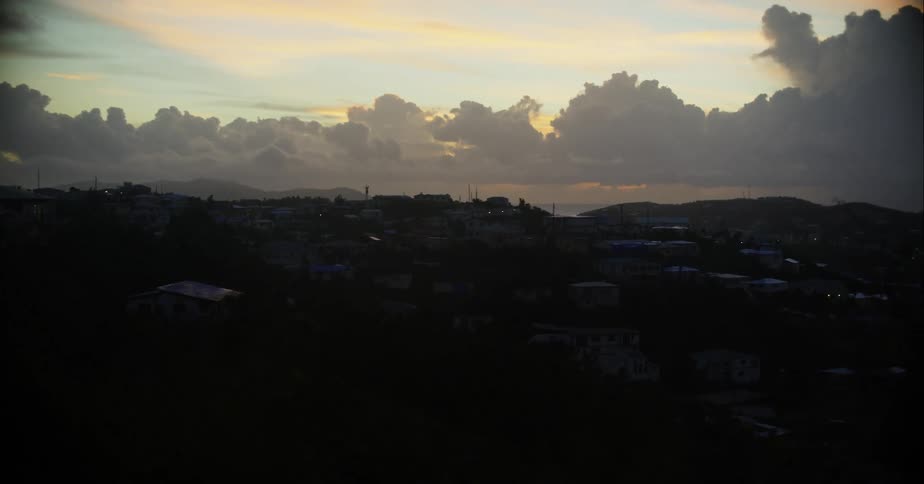 Handheld footage of a small town on the shadow of the clouds at sunset
