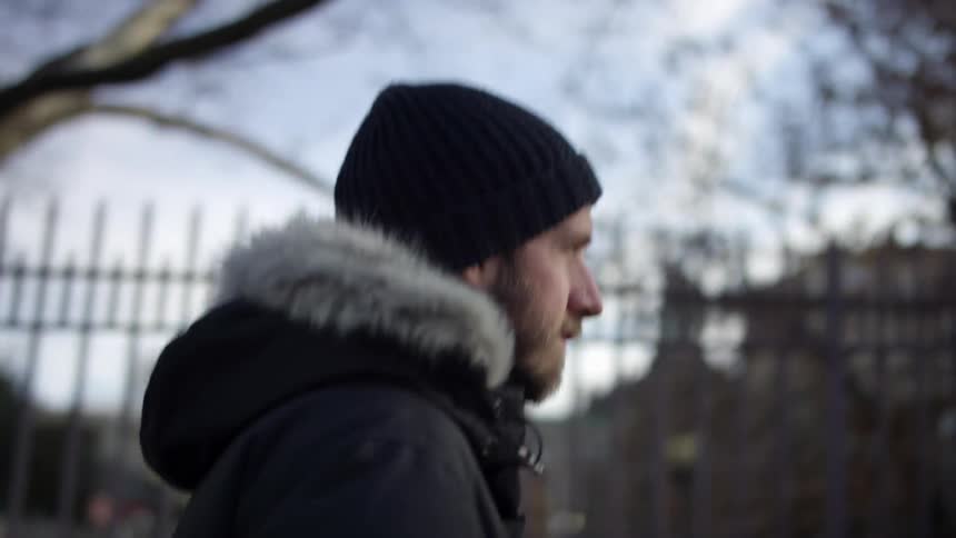 A man is walking through a neighborhood in winter