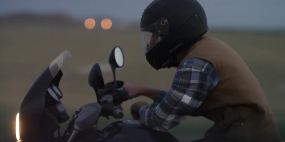 A man is riding a motorcycle with only one hand on the steering