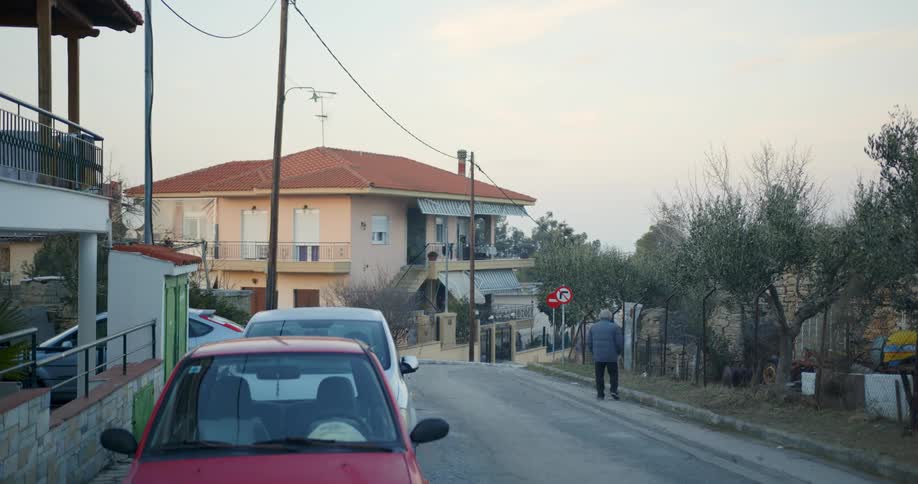 A person walks along the side of a small town road
