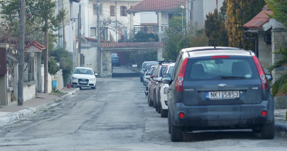 Cars parked on the side of a street in a town