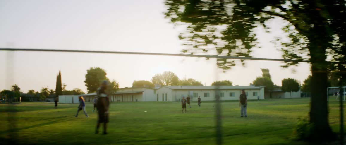 A group of people are on an outdoor public sports field