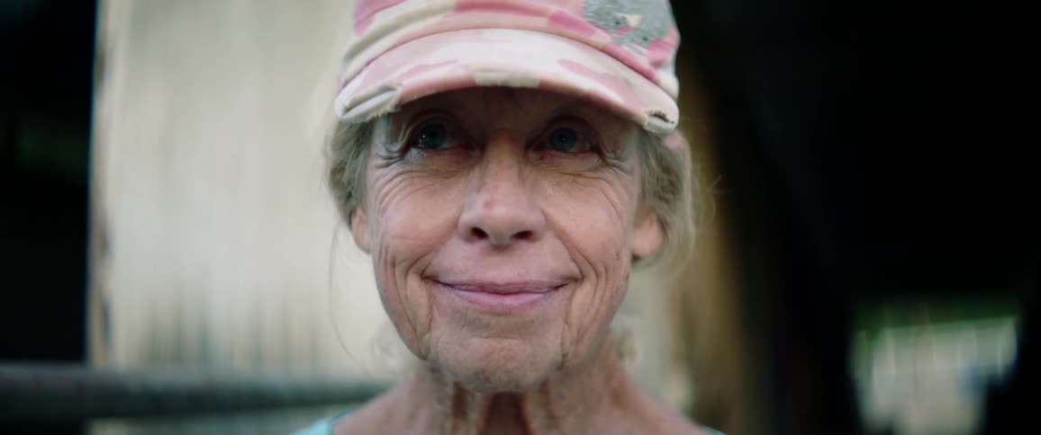 Elderly woman wearing baseball cap and smiling