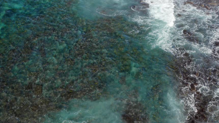 Ocean waves are moving towards the rocks