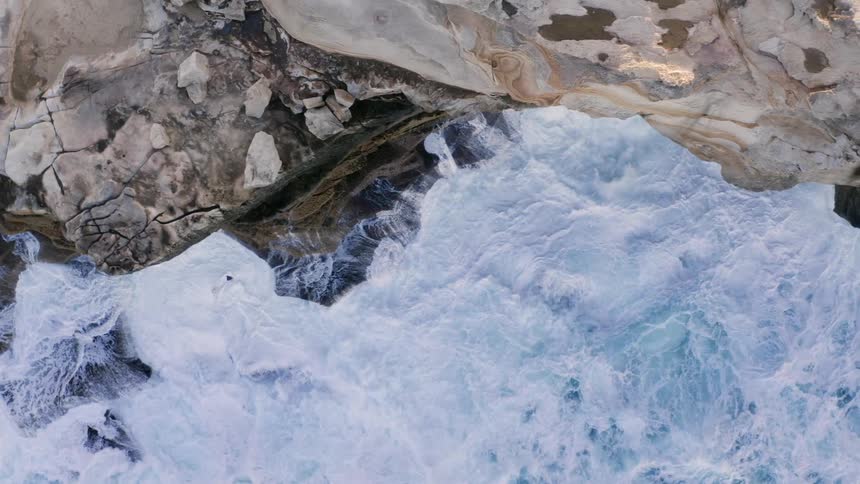 Ocean water is moving towards the cliff
