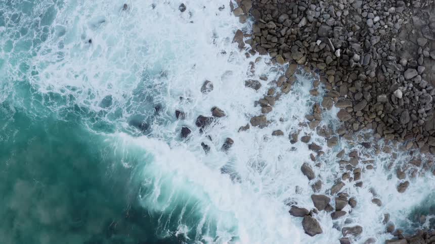 An aerial view of waves crashing in to the shore