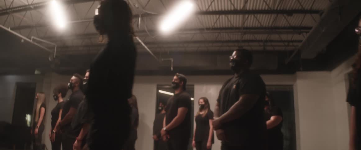 A group of men and woman stand together in a basement for equality