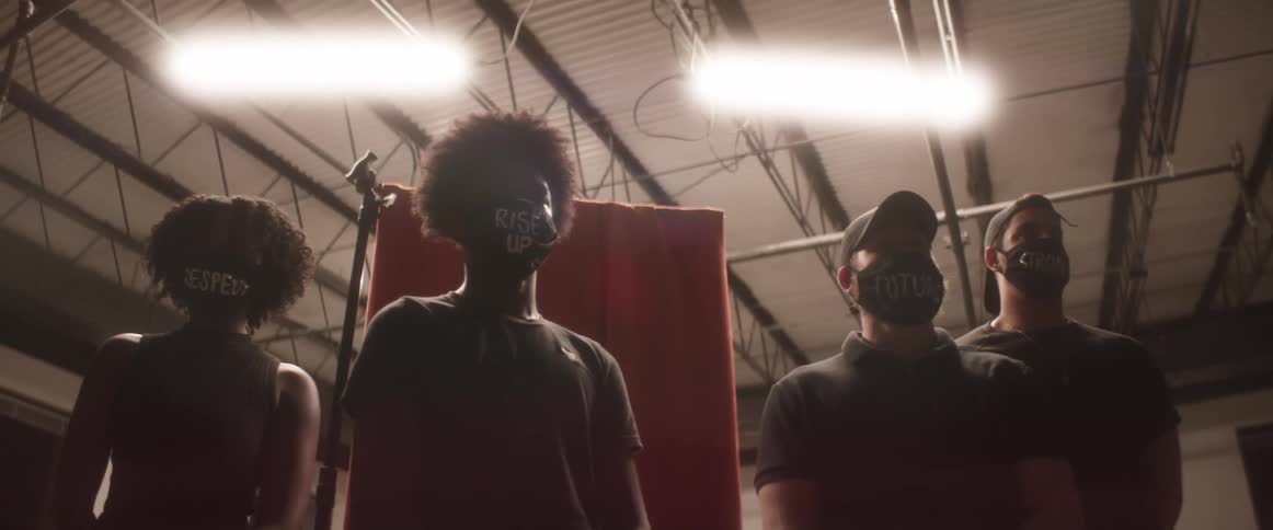 People with mask standing inside a building with lights